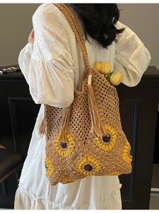 Handmade straw tote bag with yellow sunflower crochet patterns and tassel detail