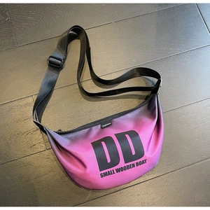 Top view of pink gradient nylon crossbody bag with black letter print on wooden floor