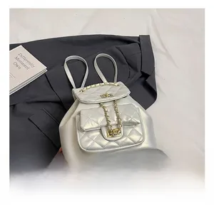 Detail shot of silver quilted faux leather backpack with gold chain strap and turn-lock