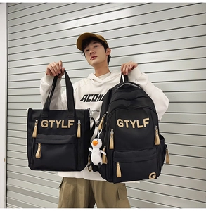 Detail of black nylon backpack and tote bag set with GTYLF letters and duck charm