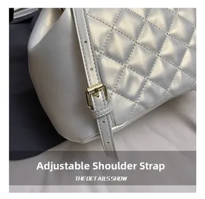 Close-up of silver quilted crossbody bag with adjustable shoulder strap and gold hardware