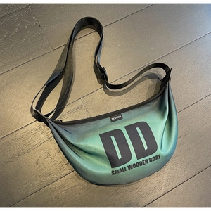 Close-up of green gradient nylon fabric texture and black letter print on cross body bag
