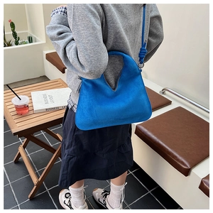 Blue matte suede tote bag with unique V-shape opening and knotted shoulder strap detail