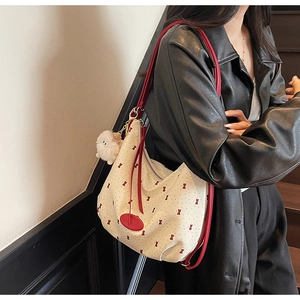 Detail of canvas hobo bag with red bow prints and cute white plush cloud charm