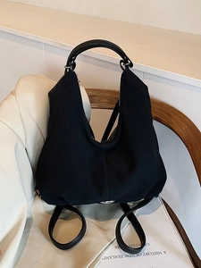 Minimalist large black canvas tote backpack with silver hardware for casual commuting