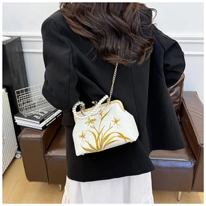 Detail of white embroidered cheongsam bag with pearl handle and floral silk pattern