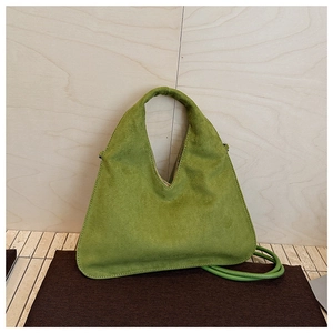 Detailed close-up showing the suede texture and soft green finish of the crossbody bag