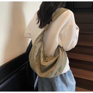 Minimalist olive green hobo bag shown on a model on stairs, highlighting casual large capacity