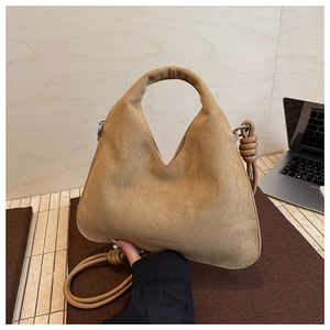 Detail of khaki suede shoulder bag featuring a V-shaped opening and a knotted strap design