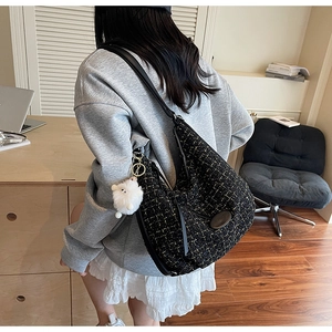 Detail of large black tweed tote bag with gold thread and cute white sheep charm