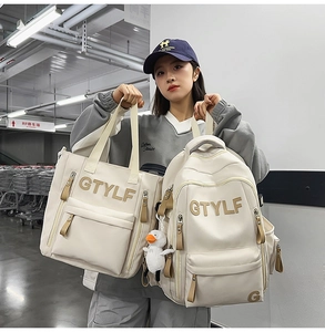 Detail view of off-white backpack and tote set with duck charm and GTYLF embroidery