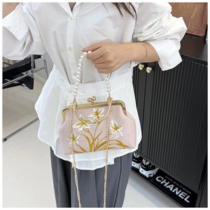 Close-up of pink qipao handbag with floral embroidery and pearl handle details