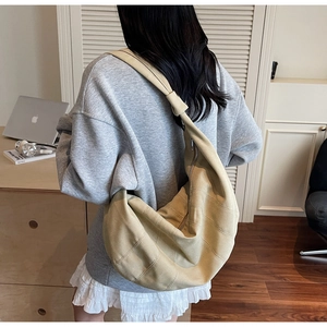 Khaki canvas crossbody dumpling bag showing large capacity and vertical seam detail