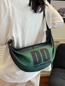 Green and black gradient crescent crossbody bag with DD print worn by a model