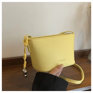 Detail of yellow lychee pattern mini bucket bag with fashion embossing and heart charm