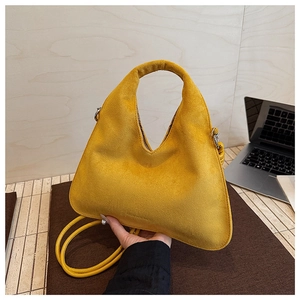 Detail of the yellow suede crossbody bag featuring embossed FASHION & BAGS logo text