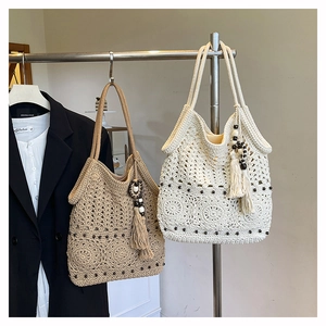 Close-up of crochet tote bag showing woven hollow flower pattern with wooden beads and tassel