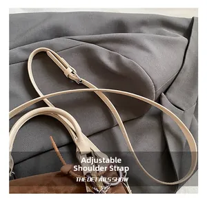 Detail of adjustable strap on a retro brown suede Boston bag with silver hardware