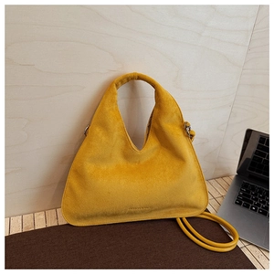 Detail of yellow matte suede crescent bag with top handle and fine leather shoulder strap