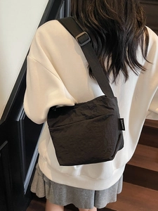 Sac seau minimaliste en nylon noir avec bandoulière réglable et finition texturée