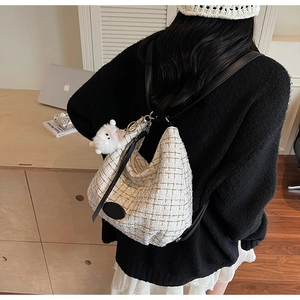 Detail of cream woven hobo bag with gold pattern and cute plush sheep charm