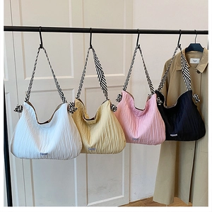 Détail de quatre sacs hobo plissés de couleurs avec bandoulières tissées rayées