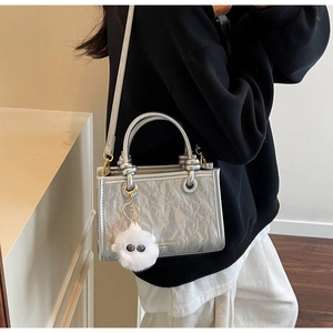 Detail of silver metallic bucket bag with pleated texture and cute white sheep charm