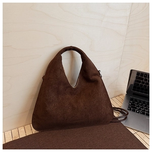 Detail of dark brown suede triangle handbag with metal D-ring and crossbody strap