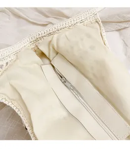 Detail view of woven tote bag showing beige fabric lining and metal zipper closure