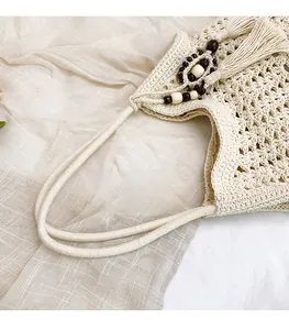 Detail of bohemian woven tote bag showing comfortable strap and decorative tassels with beads