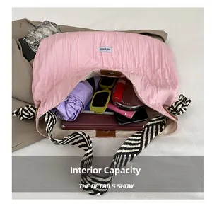 Détail intérieur du sac cabas plissé rose avec bandoulière tissée montrant la capacité