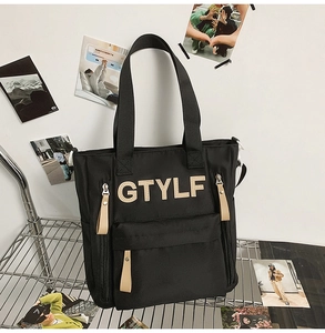 Close-up of black nylon backpack with GTYLF embroidery and leather zipper pull details