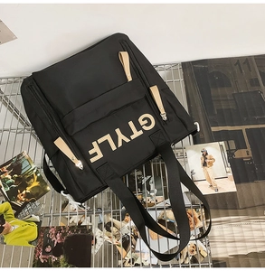 Detail of black nylon tote bag featuring GTYLF print and contrast zipper pullers