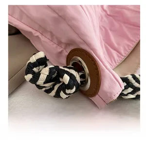 Détail du sac matelassé rose en nylon avec corde tissée et renfort en cuir marron