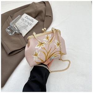 Detail of pink vintage handbag with floral embroidery and golden metal frame clasp