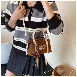 Detail der Crossbody-Tasche mit Leopardenmuster und Bärchen-Anhänger am Modell im Studio