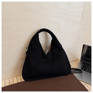 Detail of black matte suede hobo bag featuring integrated handle and silver metal rings