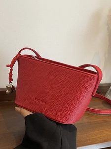 Red lychee textured bucket bag with heart charm and fashion embossed text on the front