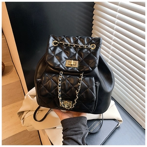 Close-up of quilted black leather backpack with gold hardware and chain drawstring detail