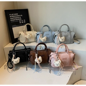 Macro display of assorted shoulder bags with cloud-textured finish and bear charms