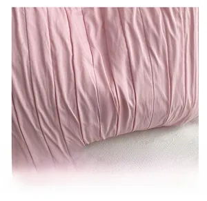 Détail de la texture plissée rose avec une étiquette de logo tissée bleue cousue