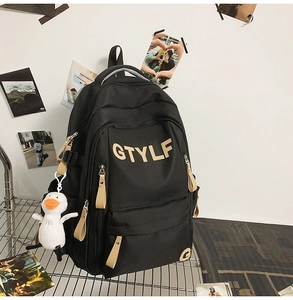 Detail of black and khaki nylon backpack featuring GTYLF patch and cute duck charm