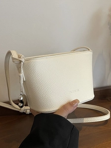 Chic beige lychee pattern leather bucket bag with fashion logo and heart pendant