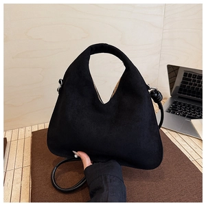 Macro detail of black suede crossbody bag with premium matte texture and dual strap design