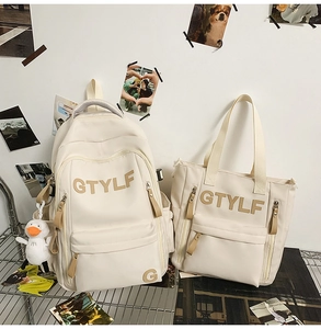 Detail view of cream-white nylon backpack and tote set with cute duck charm and GTYLF logo