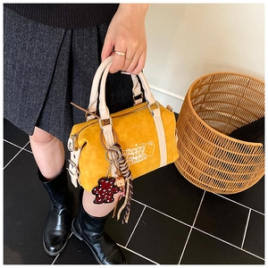 Streetstyle-Aufnahme der gelben Boston-Tasche mit Bärenprint und Anhängern für den Alltag