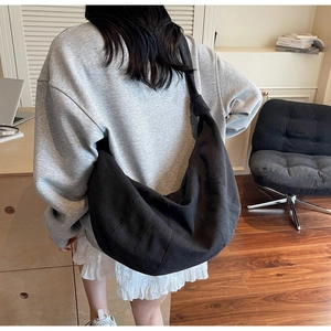 Detail of the black canvas hobo bag showing a unique knotted strap and spacious design
