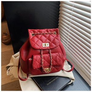 Detailed view of red quilted PU leather backpack with gold twist lock and chain drawstring