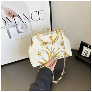 Close-up of floral embroidery on a vintage qipao handbag with golden metallic clasp