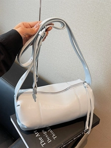 Light blue faux leather pillow bag with adjustable shoulder strap and cylinder design